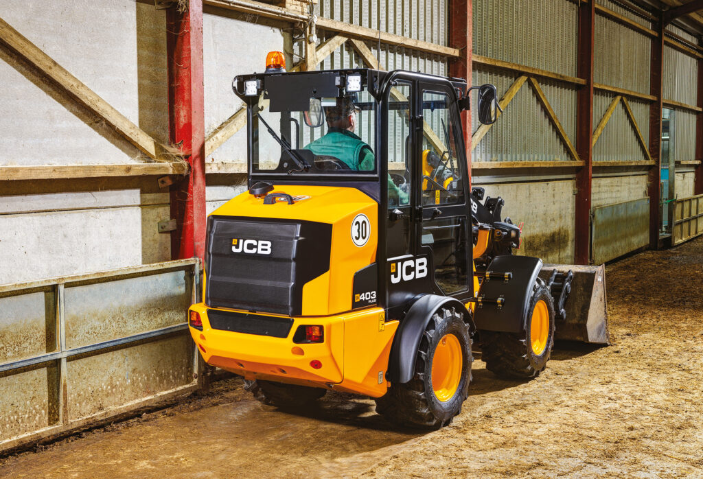 JCB 403 Agri -pyöräkuormaaja tyhjentämässä navetan lattiaa.