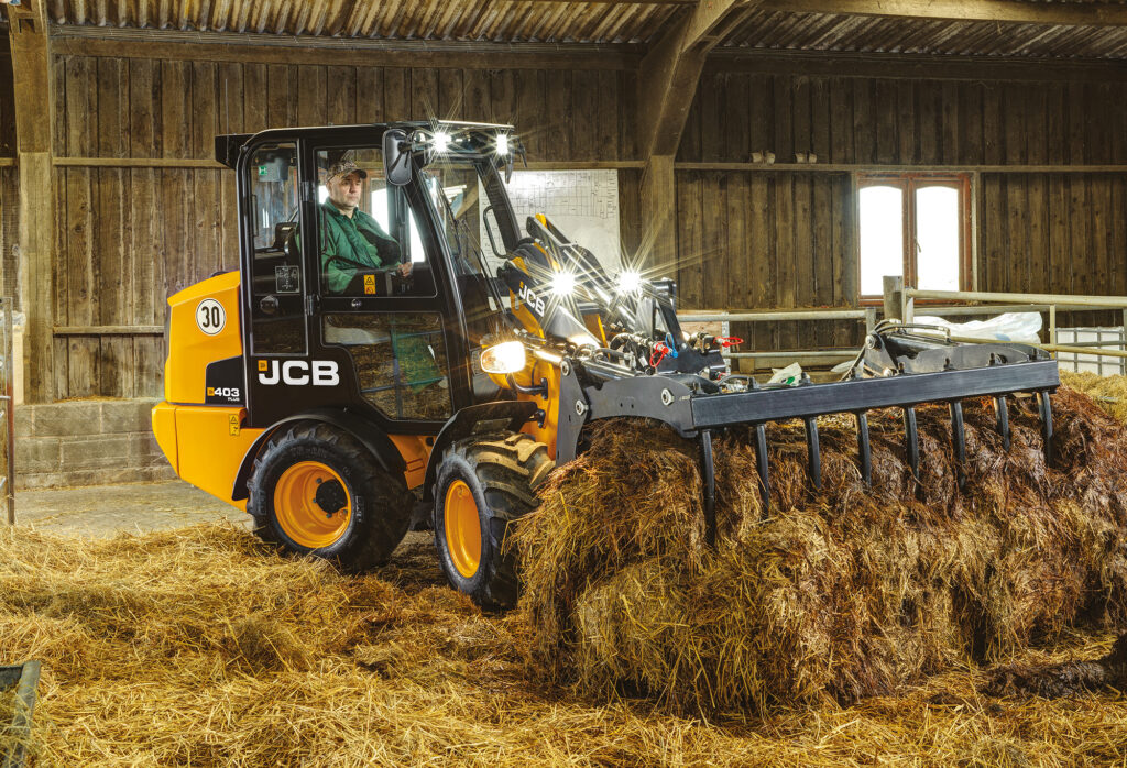 JCB 403 Agri -pyöräkuormaaja nostamassa rehua.