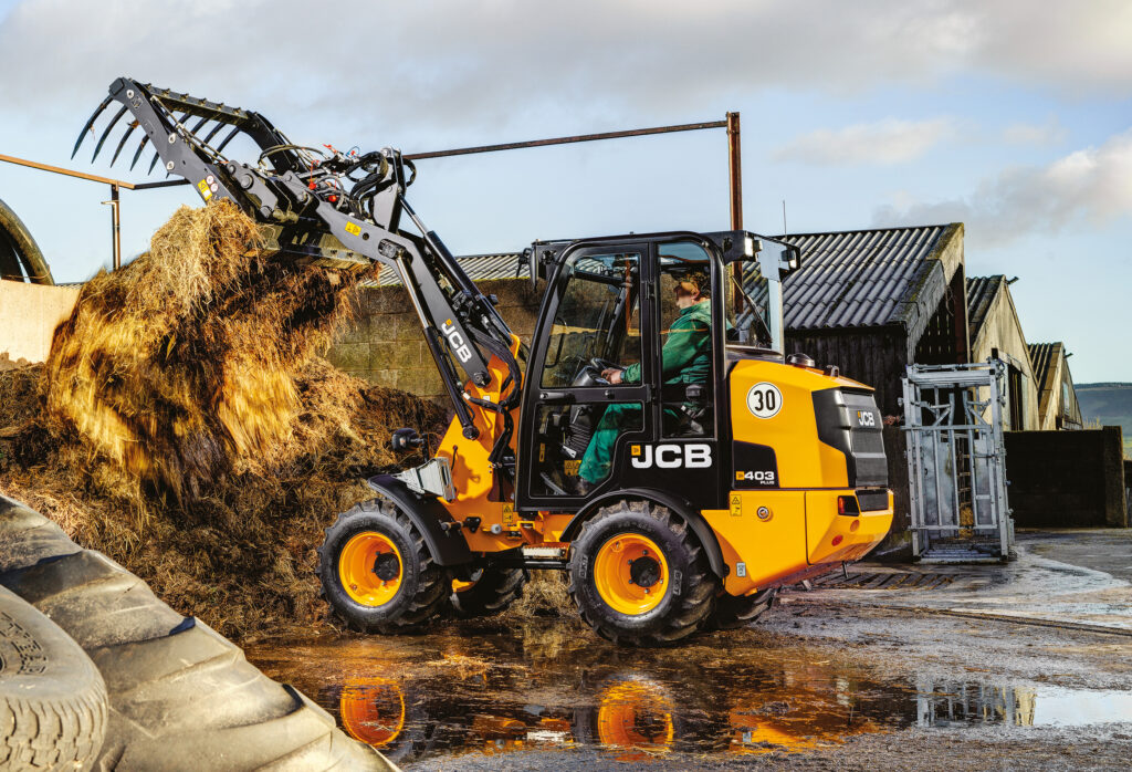 JCB 403 Agri -pyöräkuormaaja nostamassa rehua.