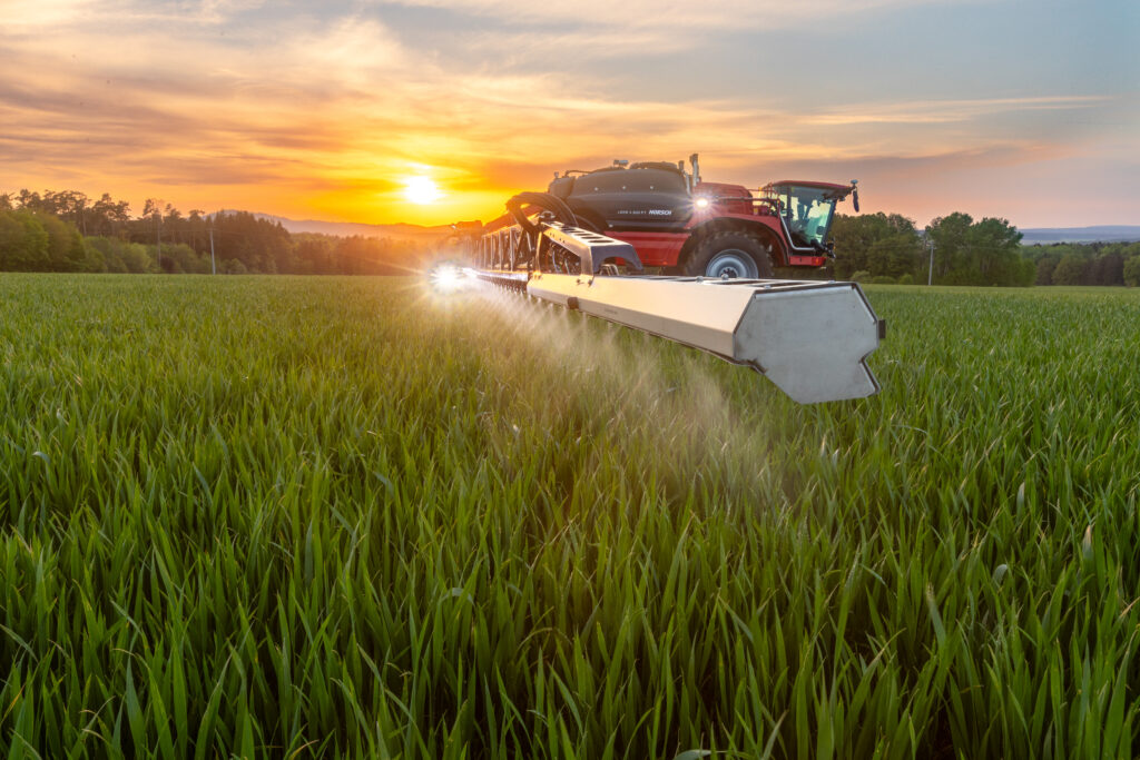 Horsch Leeb -ajettava kasvinsuojeluruisku ruiskuttamassa pellolla auringonlaskun aikaan.