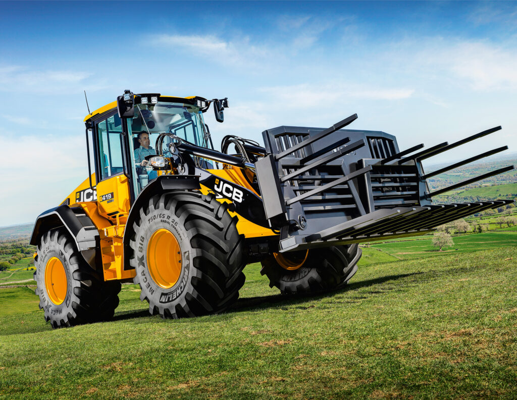 JCB 419S-pyöräkuormaaja pellolla rehutalikon kanssa.