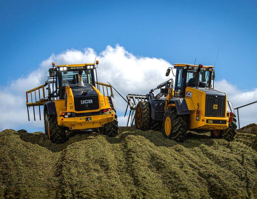 JCB 419S-pyöräkuormaaja siirtämässä rehua aumalla.