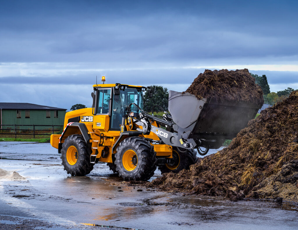 JCB 427 Agri -pyöräkuormaaja nostamassa lantaa.