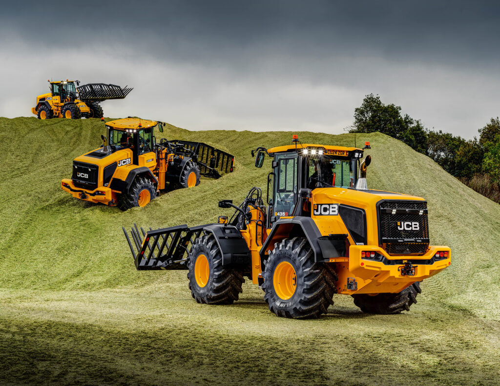 JCB 435S -pyöräkuormaajat aumalla työntämässä rehua.