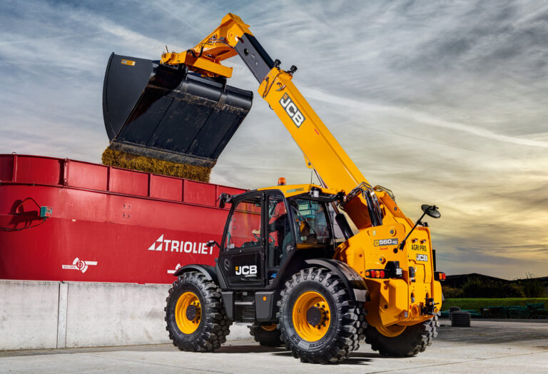 JCB 560-80 Agri -kurottaja kaatamassa rehua apevaunuun.