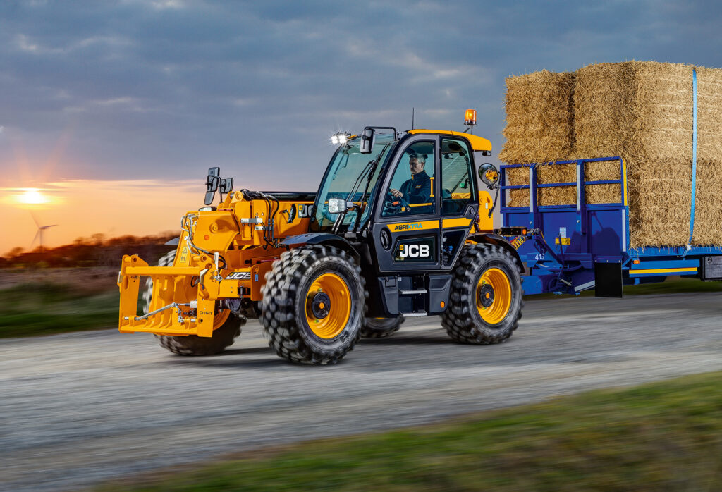 JCB 560-80 Agri -kurottaja ajamassa olkipaaleja tiellä.