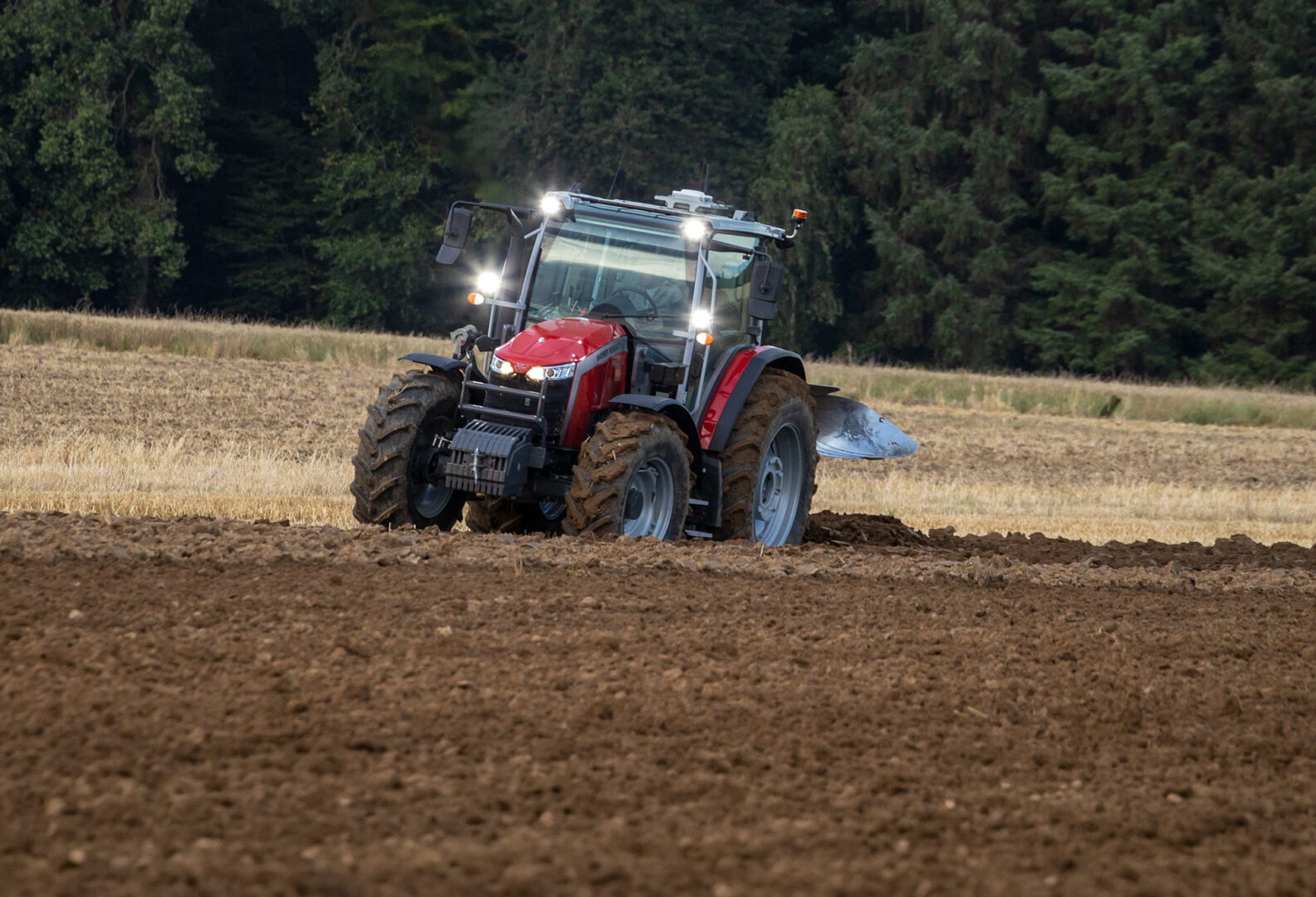 Massey Ferguson 5M -traktori kyntämässä pellolla.