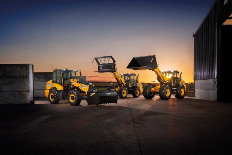 Kolme JCB Telemasteria illan hämärässä.