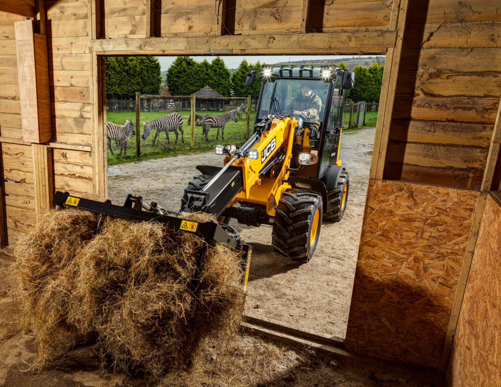 JCB TM110 Agri -kurottava pyöräkuormaaja nostamassa heinää latoon.