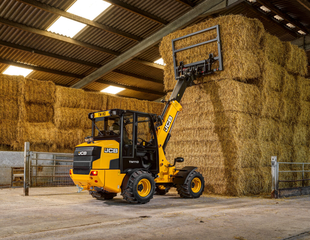 JCB TM110 Agri -kurottava pyöräkuormaaja nostamassa olkipaaleja.