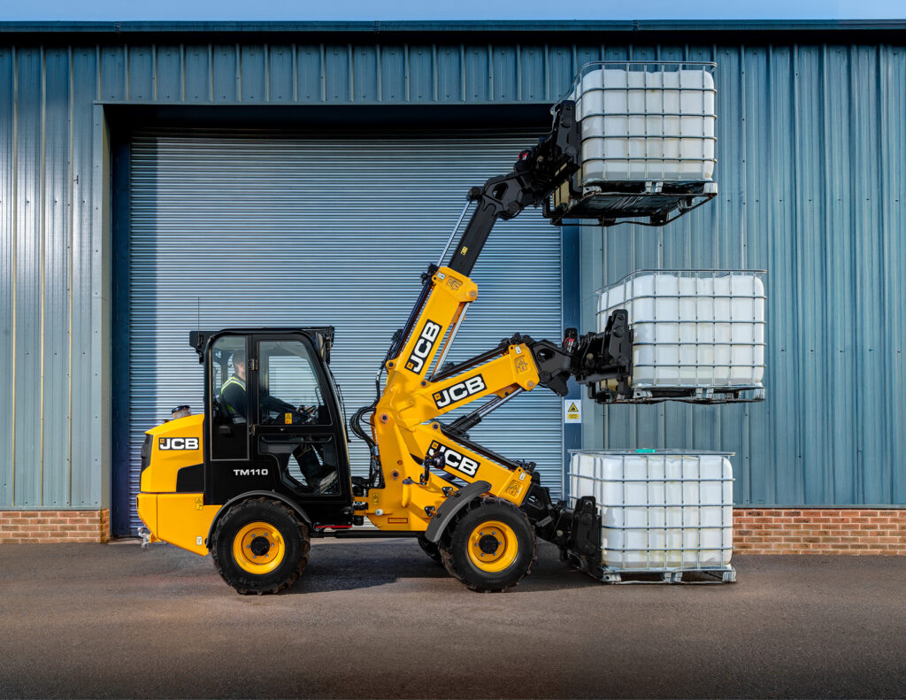 JCB TM110 Agri -kurottava pyöräkuormaaja nostamassa IBC-konttia.