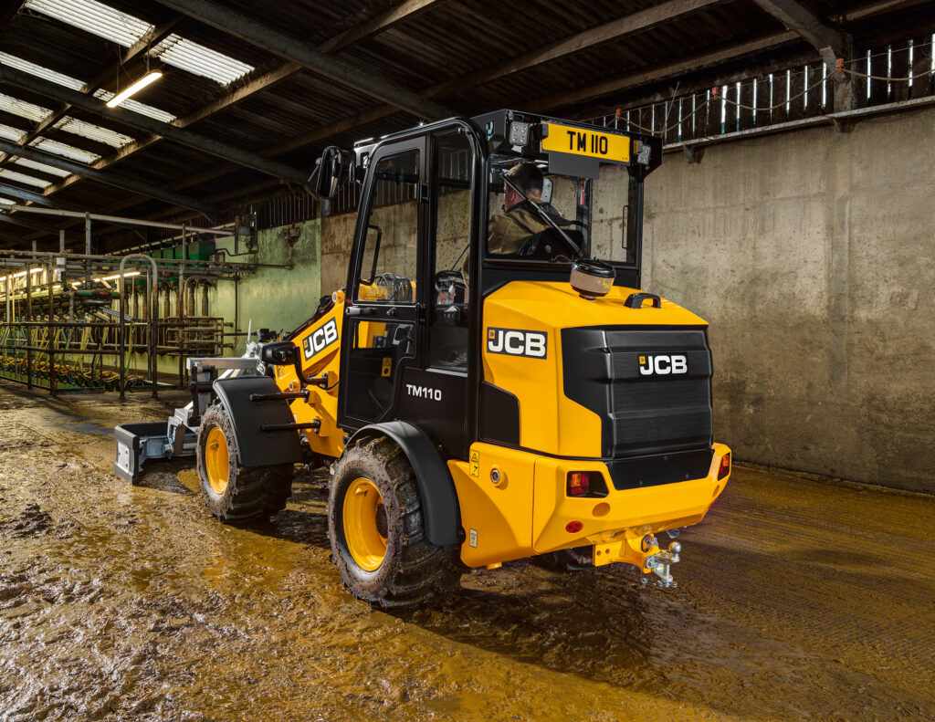 JCB TM110 Agri -kurottava pyöräkuormaaja tyhjentämässä navetan lantalaa.