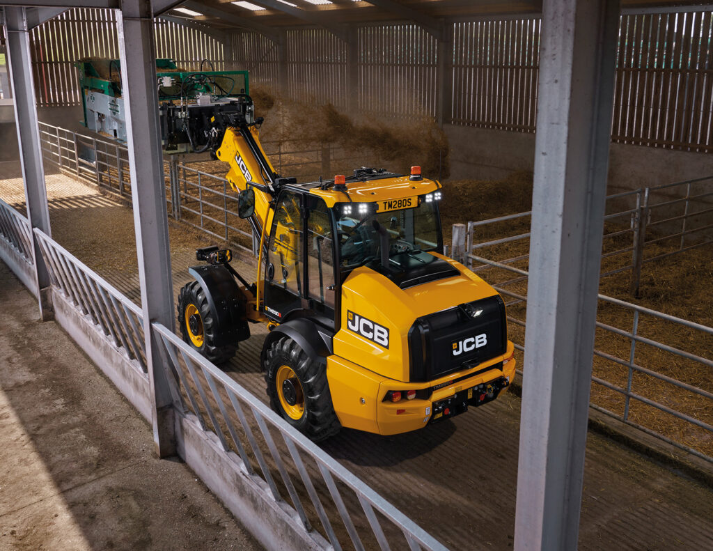JCB TM280S Agri -kurottava pyöräkuormaaja kuivittamassa navetassa.