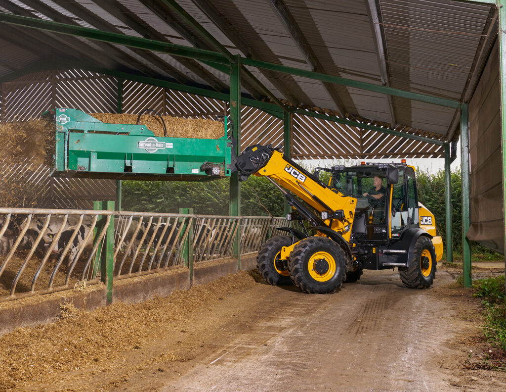 JCB TM280S Agri -kurottava pyöräkuormaaja kuivittamassa oljella navetassa.
