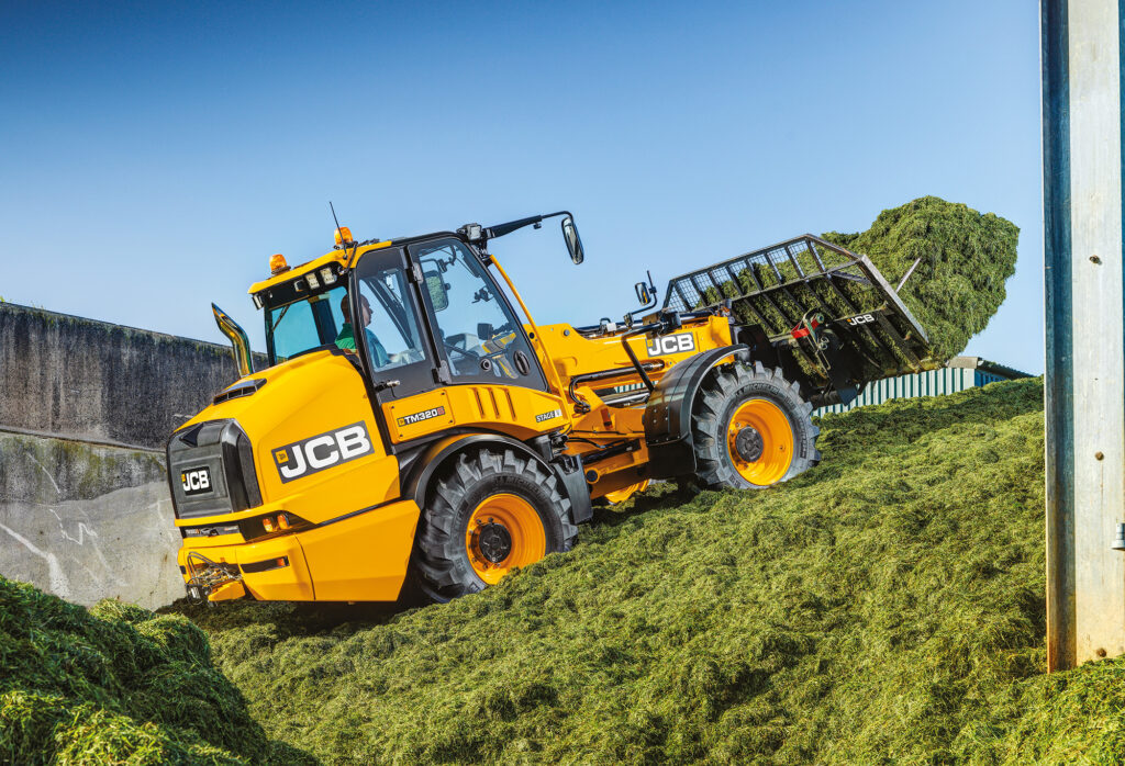 JCB TM320S Agri -kurottava pyöräkuormaaja työntämässä rehua aumalla.