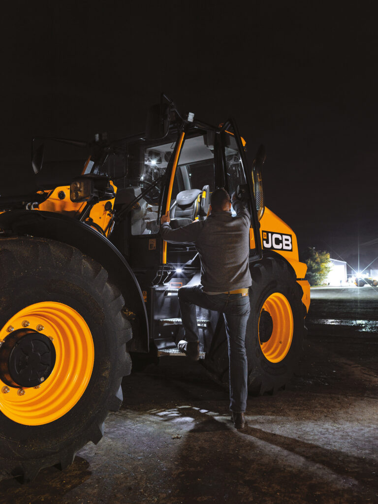 Henkilö nousemassa JCB TM420S Agri -kurottavaan pyöräkuormaajaan.