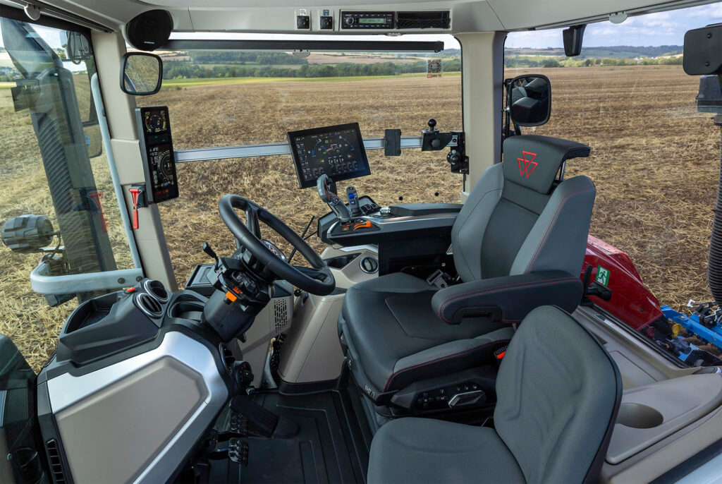 Massey Ferguson 7S MARK2 -traktorin ohjaamo kultivoidulla pellolla.